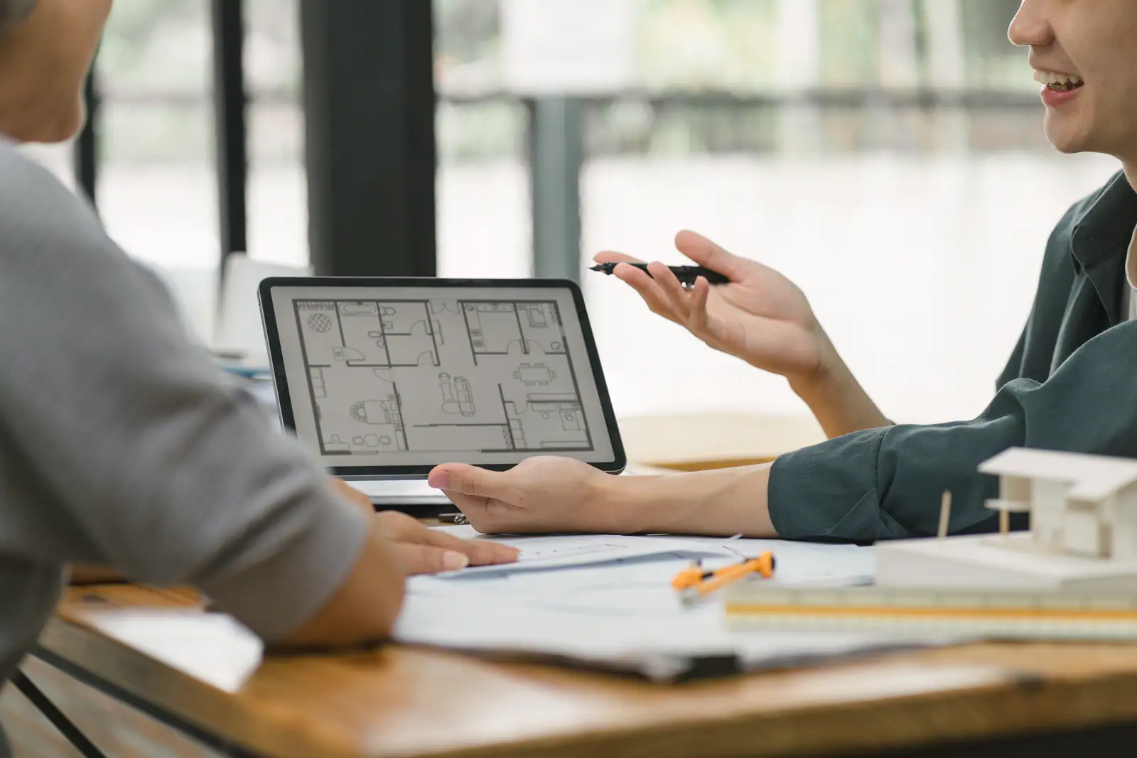 Homeowners and a designer reviewing a floor plan together on a tablet