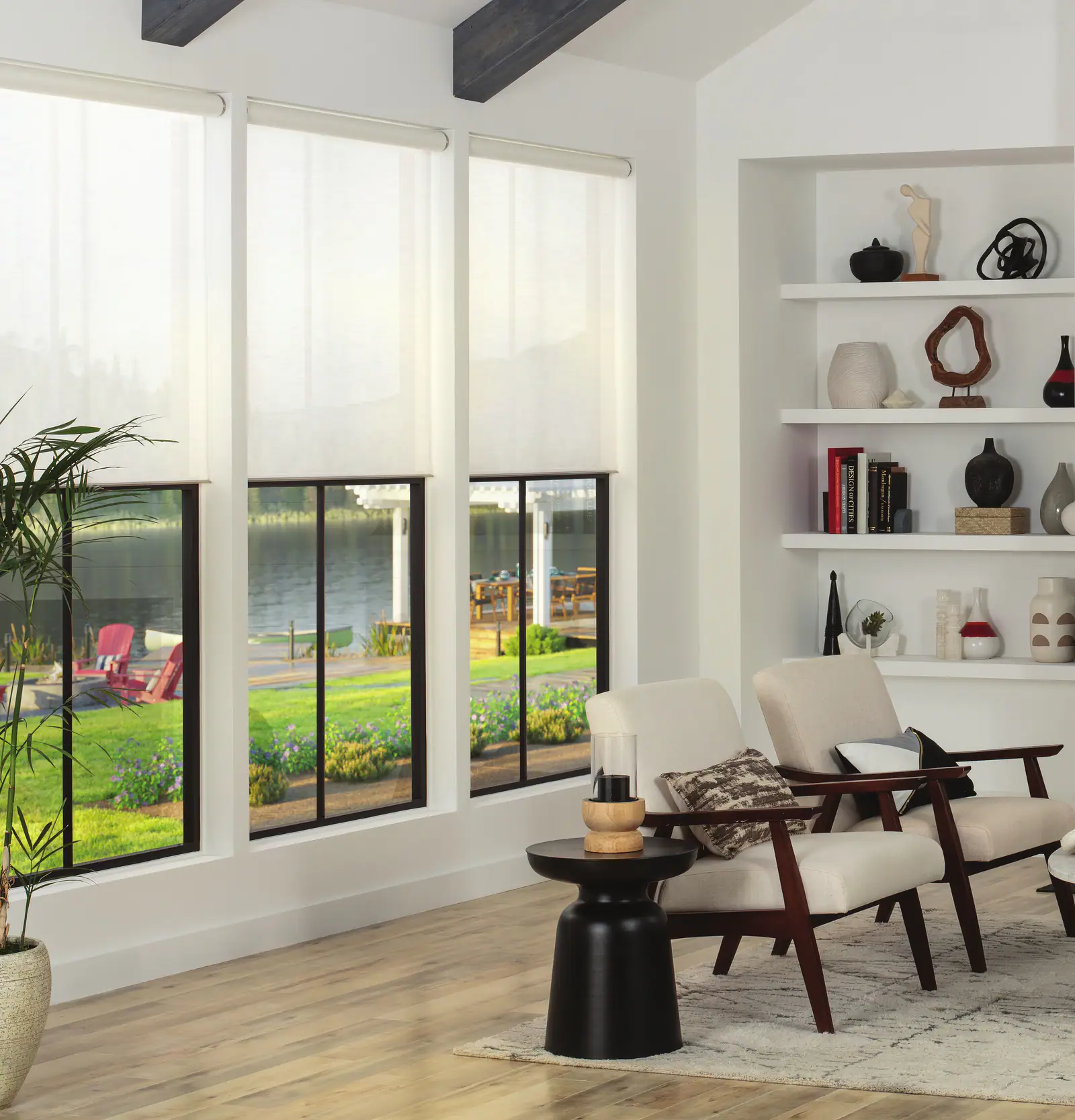 A bright sunroom with armchairs, sheer Lutron shades drawn partway down the windows